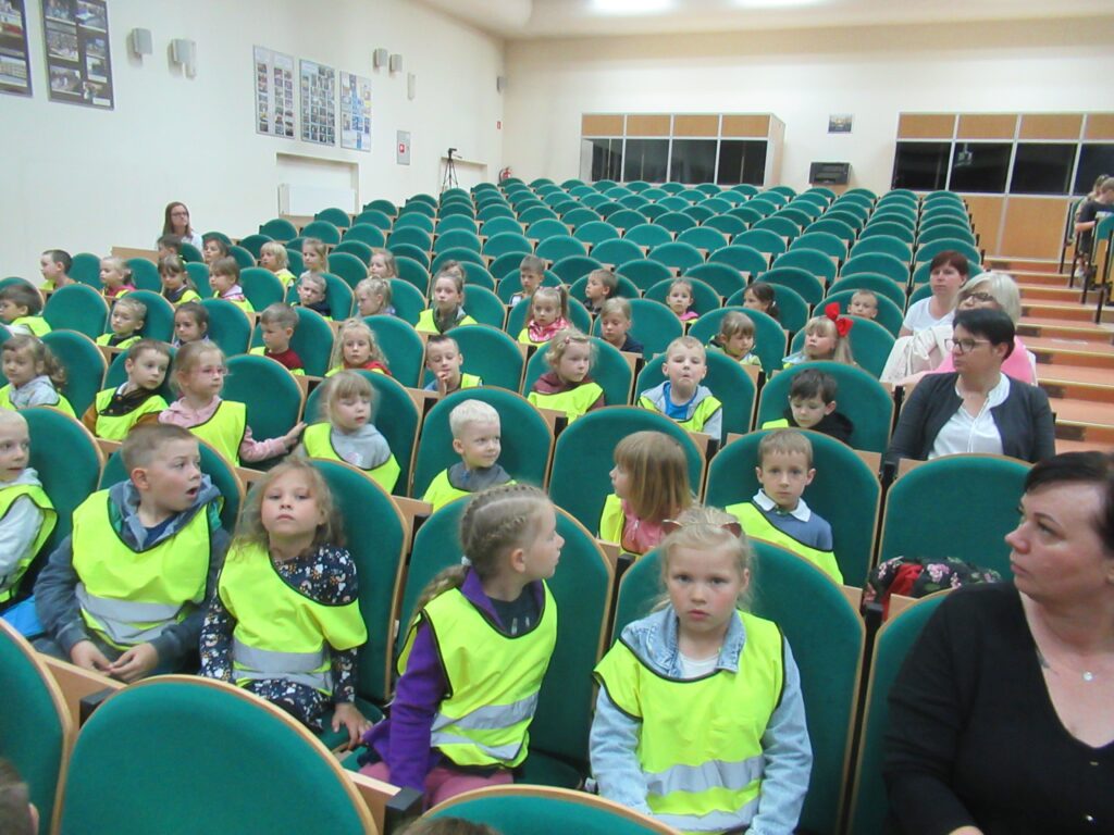 Zdjęcie przedstawia grupę siedzących ludzi w sali.