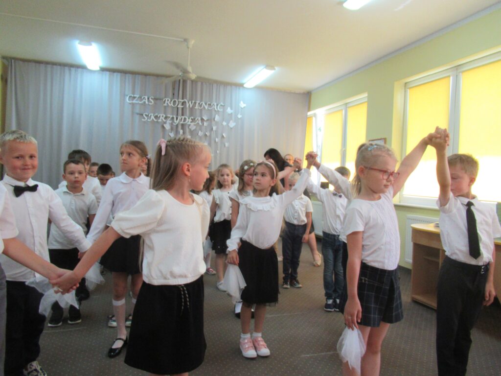 Zdjęcie przedstawia grupę tańczących dzieci w sali przedszkolnej