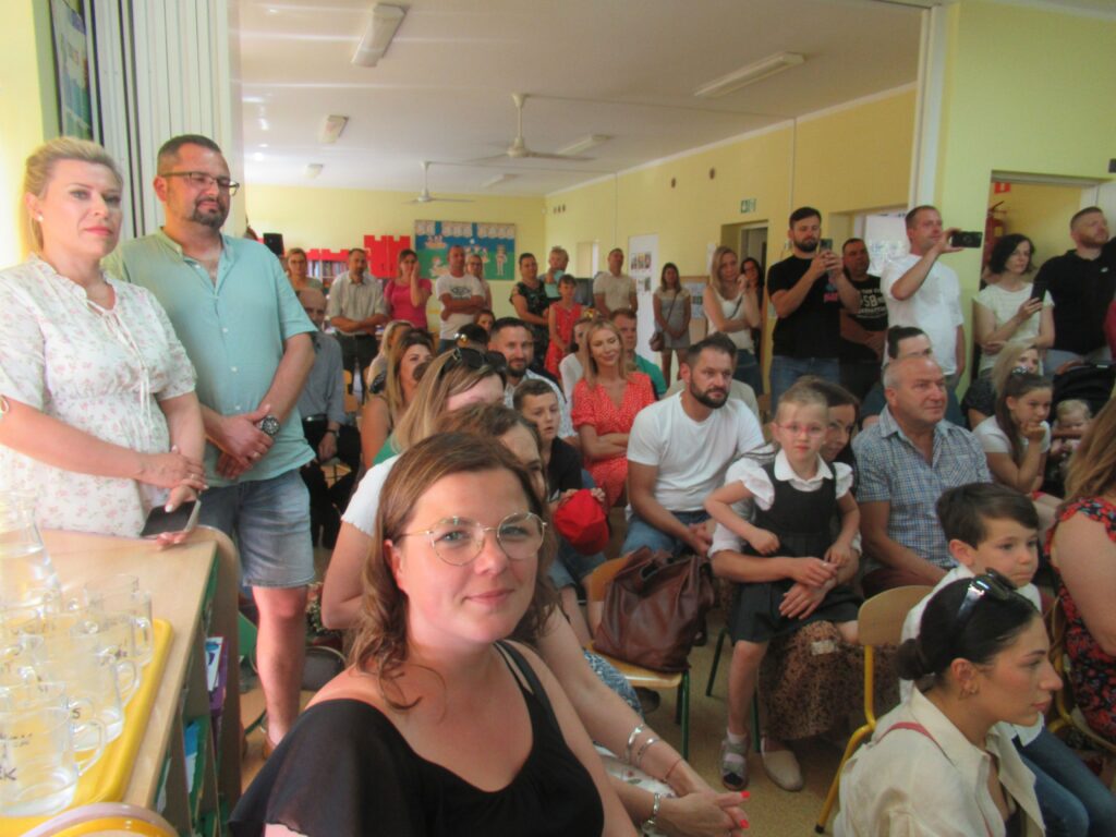 Zdjęcie przedstawia grupę ludzi w sali przedszkolnej