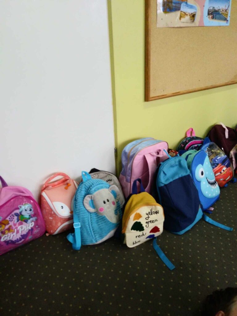 Zdjęcie plecaków w sali przedszkolnej.