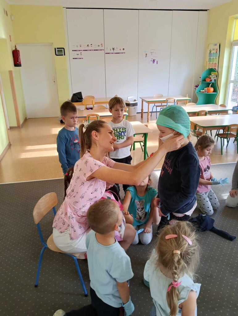Zdjęcie przedstawia grupę ludzi w sali przedszkolnej.