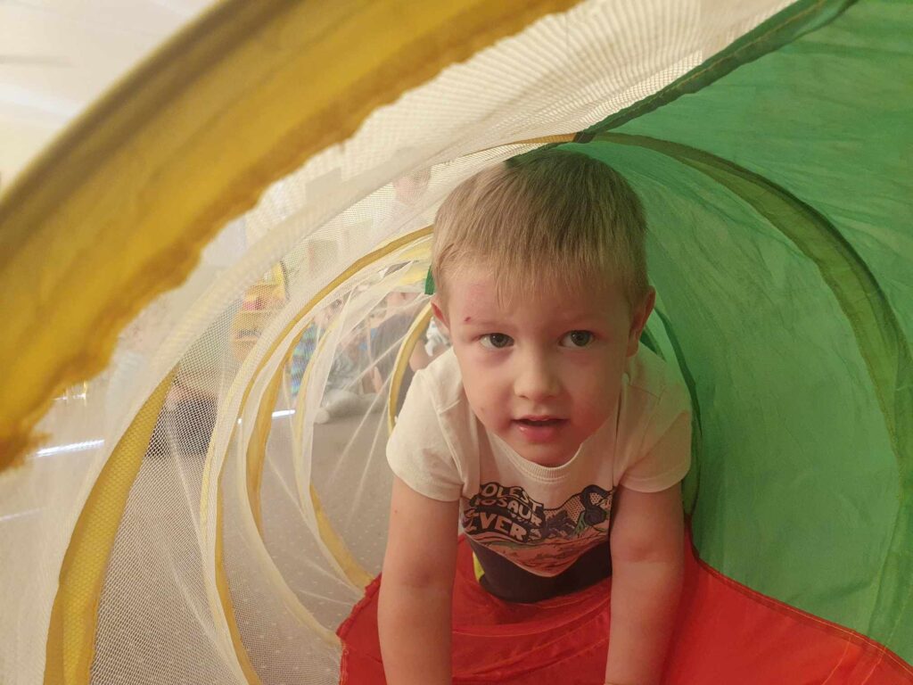 Zdjęcie przedstawia dziecko bawiące się w sali przedszkolnej.