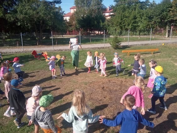 Zdjęcie przedstawia bawiące się dzieci na placu zabaw.