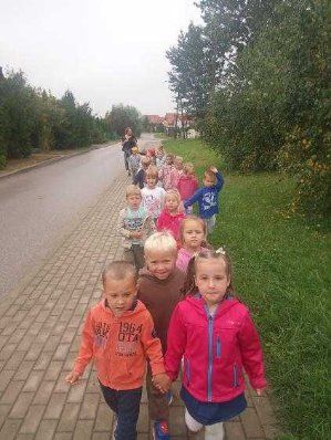 Zdjęcie przedstawia grupę spacerujących dzieci.