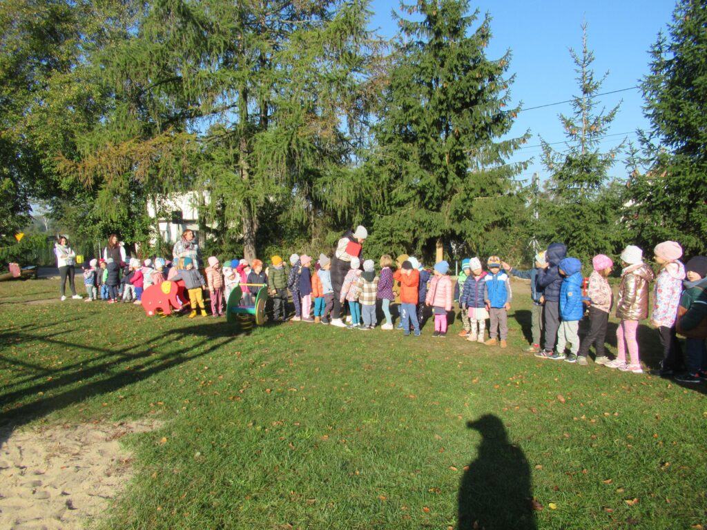 Zdjęcie przedstawia grupę ludzi w ogrodzie przedszkolnym.