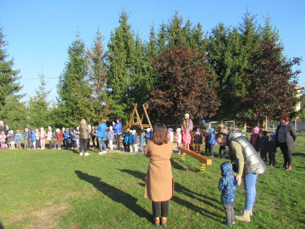 Zdjęcie przedstawia grupę ludzi w ogrodzie przedszkolnym.