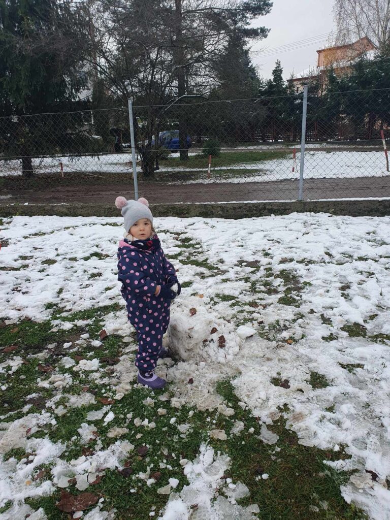 Zdjęcie przedstawia dziecko w ogrodzie przedszkolnym.