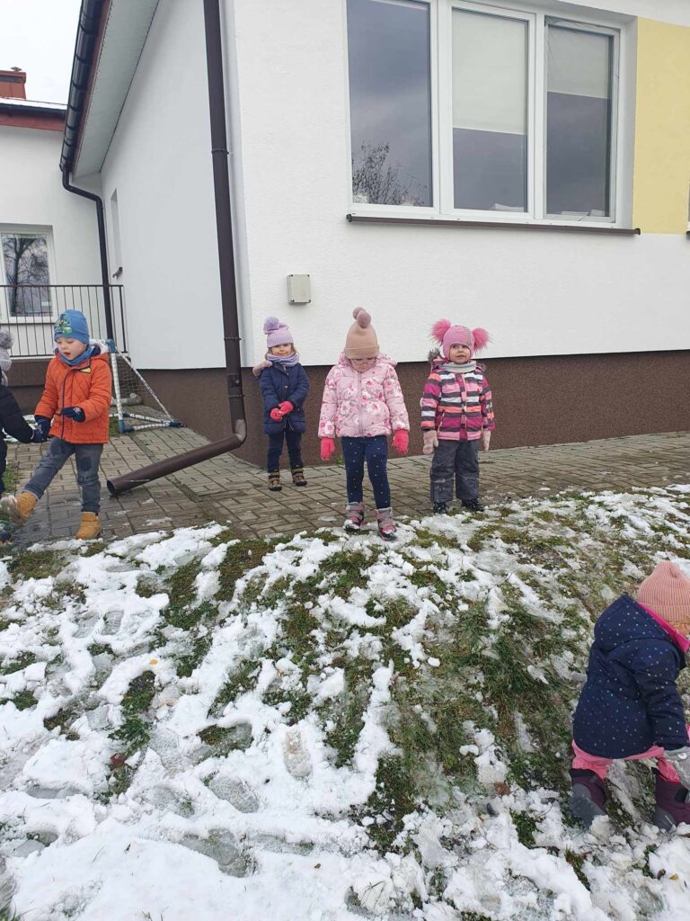 Zdjęcie przedstawia dzieci w ogrodzie przedszkolnym.