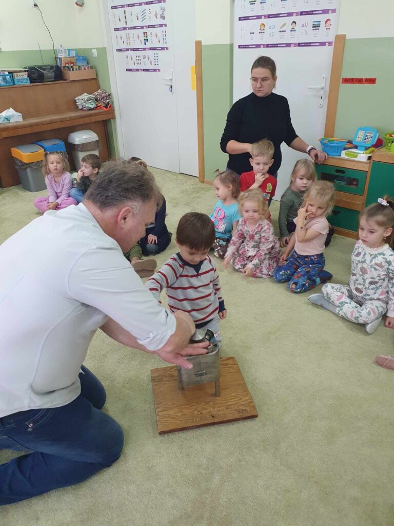 Zdjęcie przedstawia grupę ludzi w sali przedszkolnej.