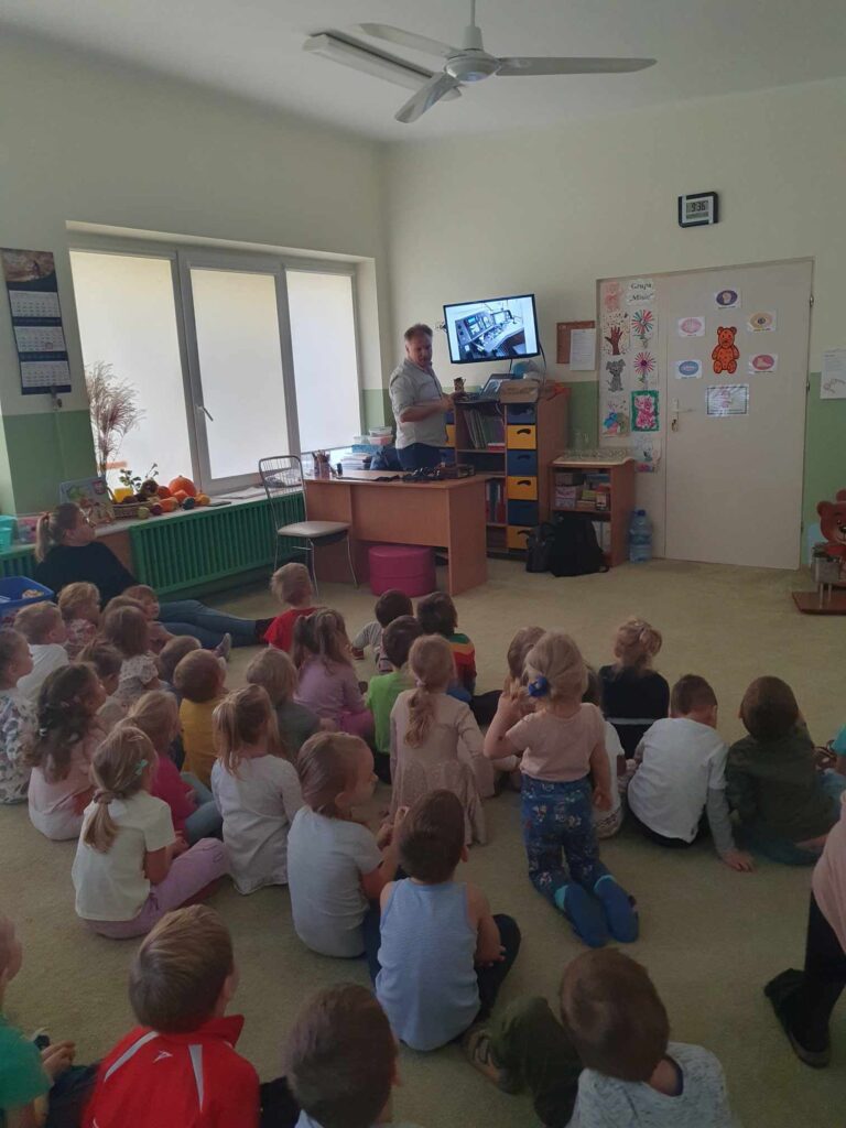 Zdjęcie przedstawia grupę ludzi w sali przedszkolnej.