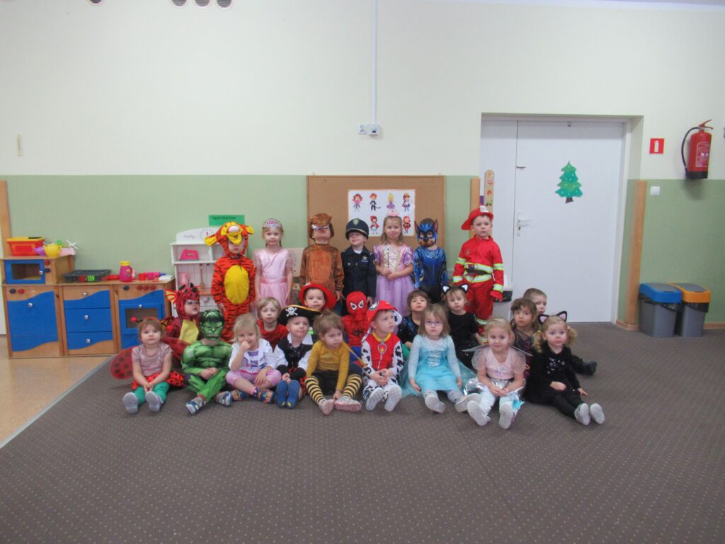 Zdjęcie przedstawia grupę dzieci w sali przedszkolnej.