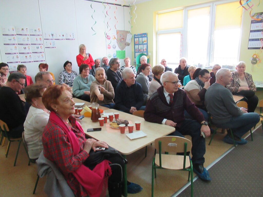 Zdjęcie przedstawia grupę ludzi w sali przedszkolnej.