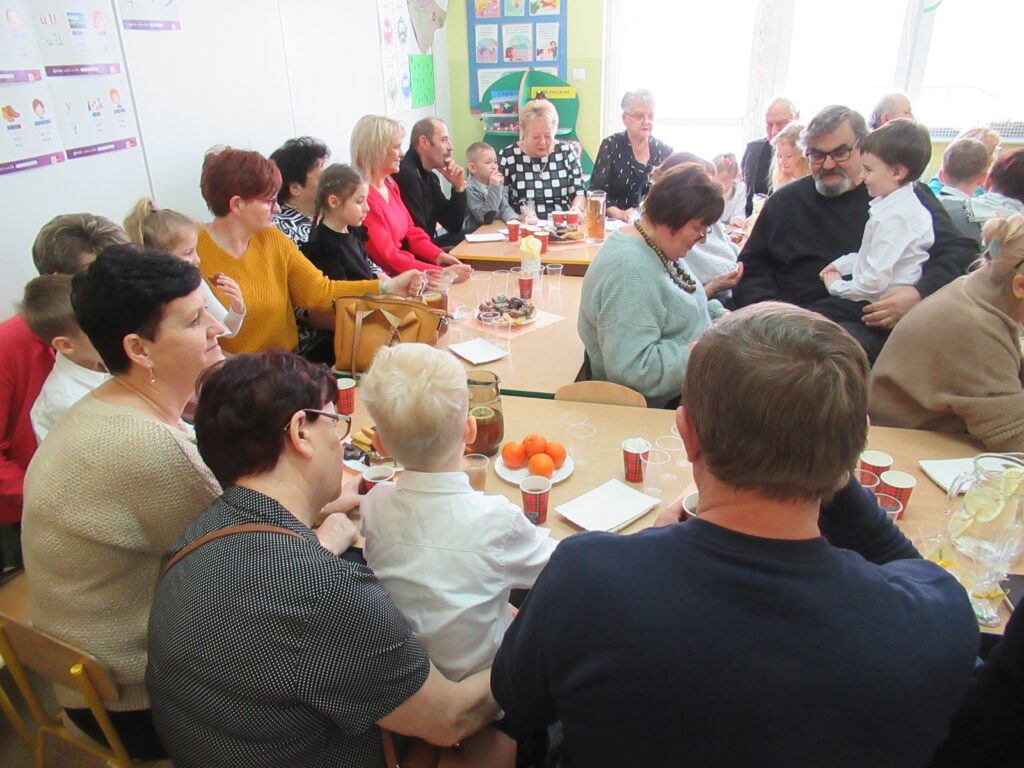 Zdjęcie przedstawia grupę ludzi w sali przedszkolnej.