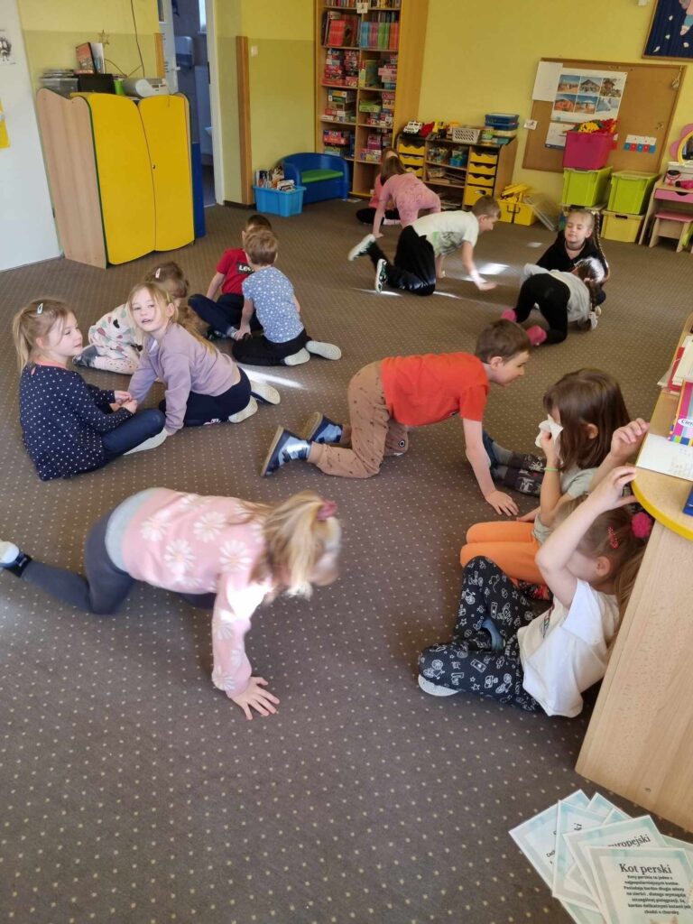 Zdjęcie przedstawia dzieci bawiące się w sali przedszkolnej.