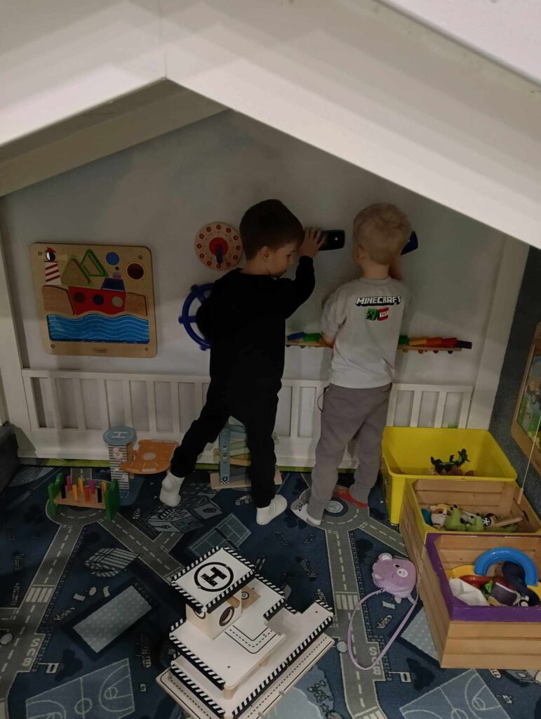 Zdjęcie przedstawia dwoje dzieci w sali zabaw.