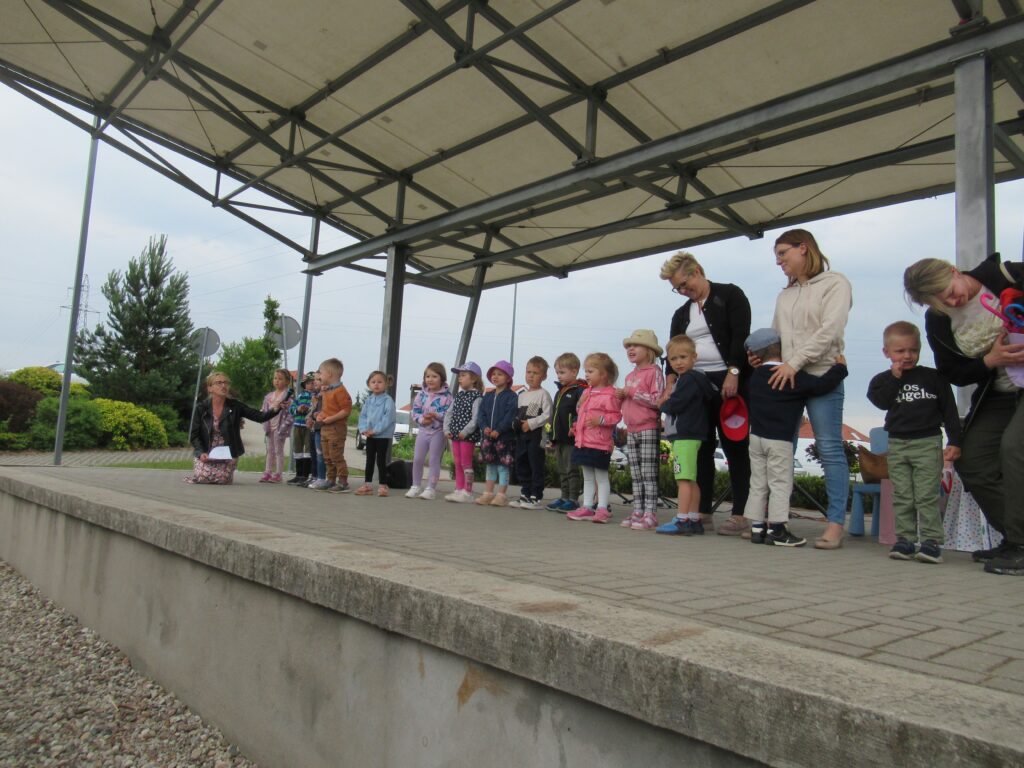 Zdjęcie przedstawia panie oraz grupę dzieci na scenie.