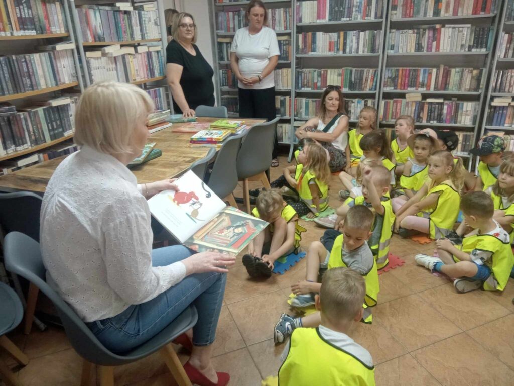 Zdjęcie przedstawia panie oraz dzieci w bibliotece.