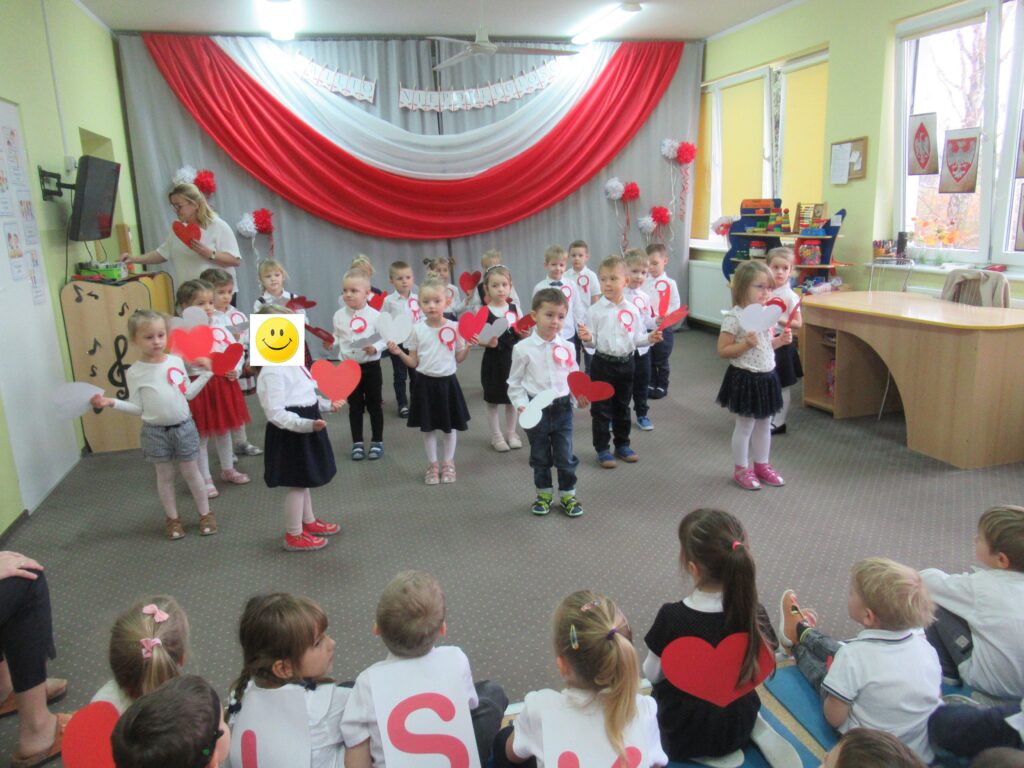 Zdjęcie przedstawia grupę ludzi w sali przedszkolnej.