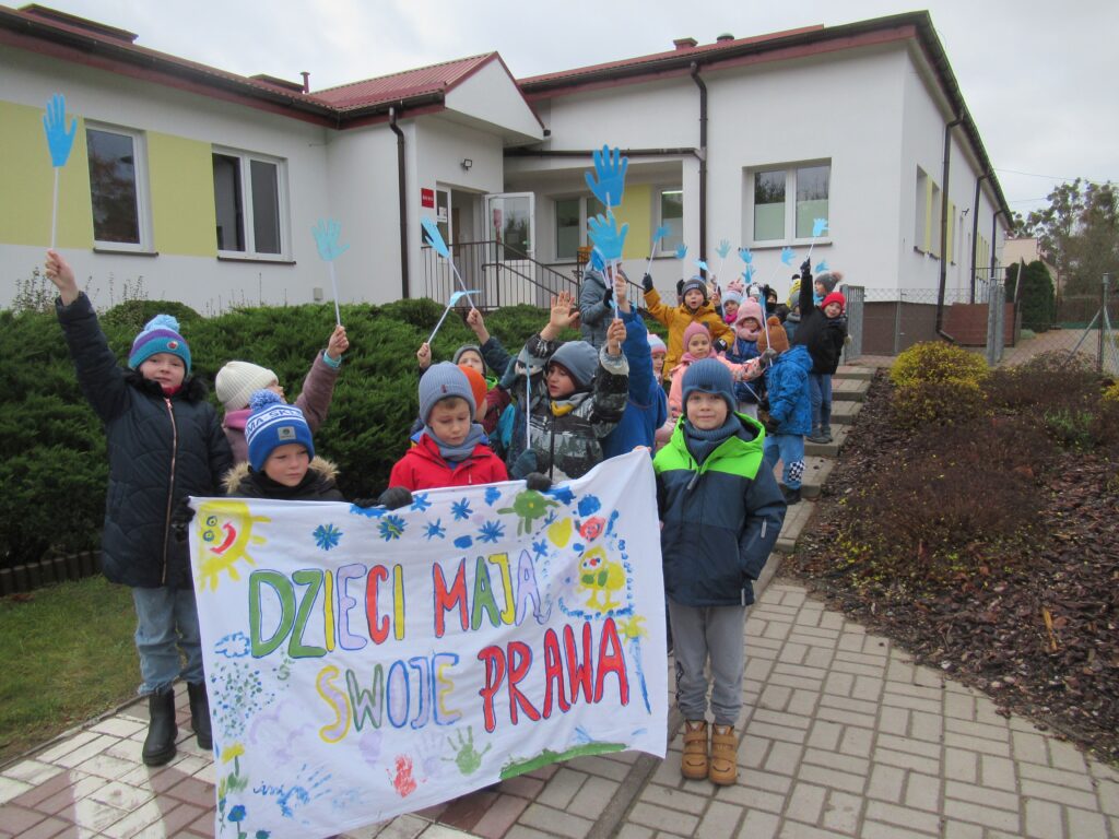 Zdjęcie przedstawia grupę dzieci trzymających transparent z napisem -Dzieci maja swoje prawa.