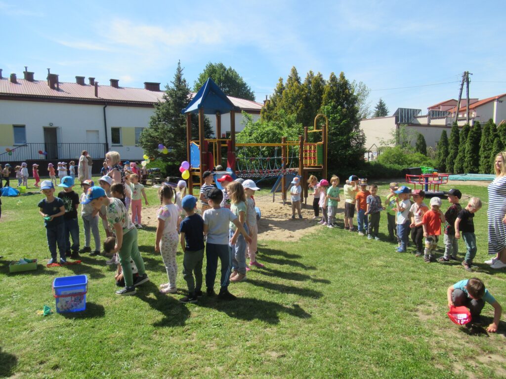 Zdjęcie przedstawia grupę ludzi w ogrodzie przedszkolnym.