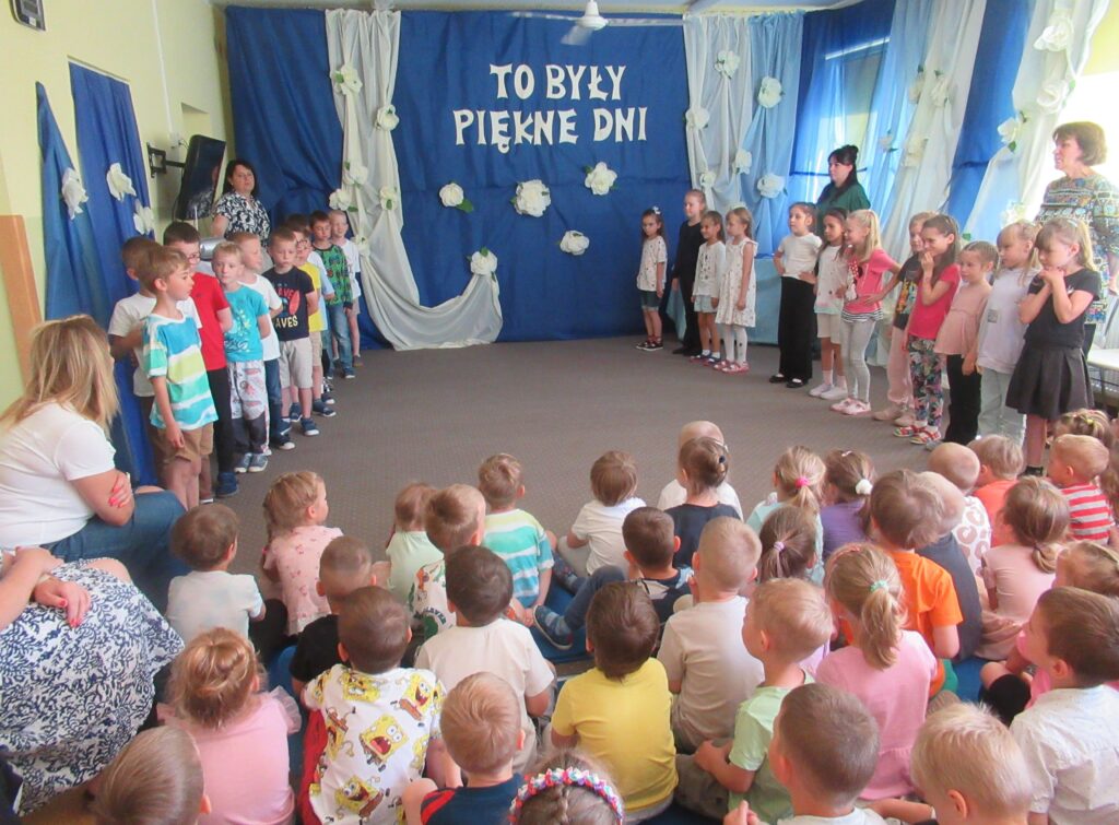 Zdjęcie przedstawia grupę ludzi w sali przedszkolnej.