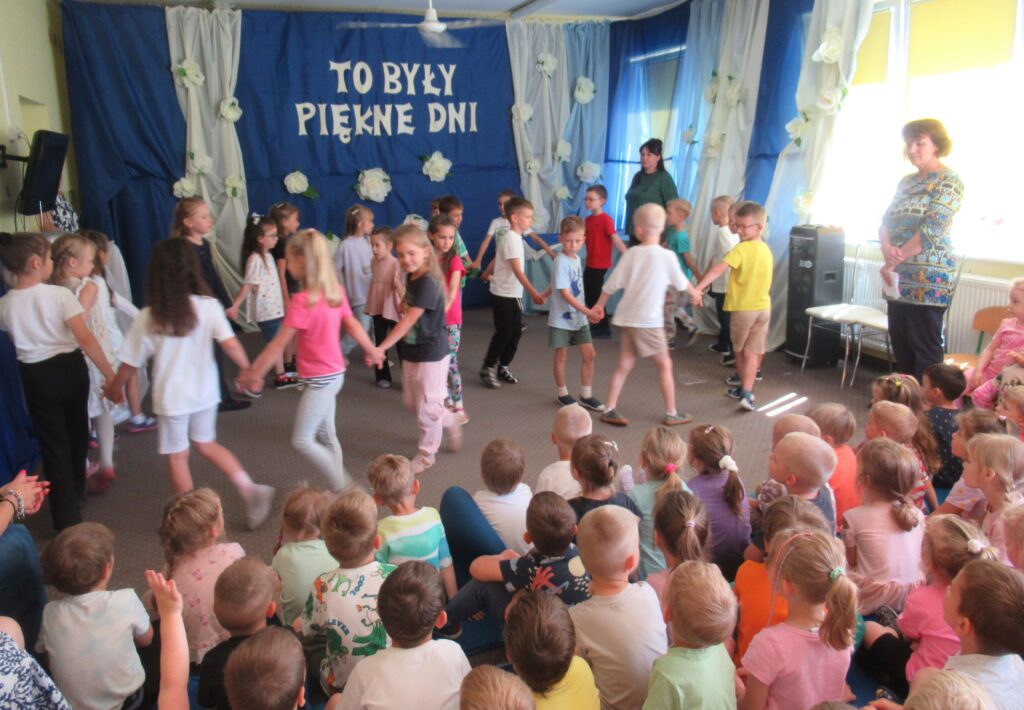 Zdjęcie przedstawia grupę ludzi w sali przedszkolnej.