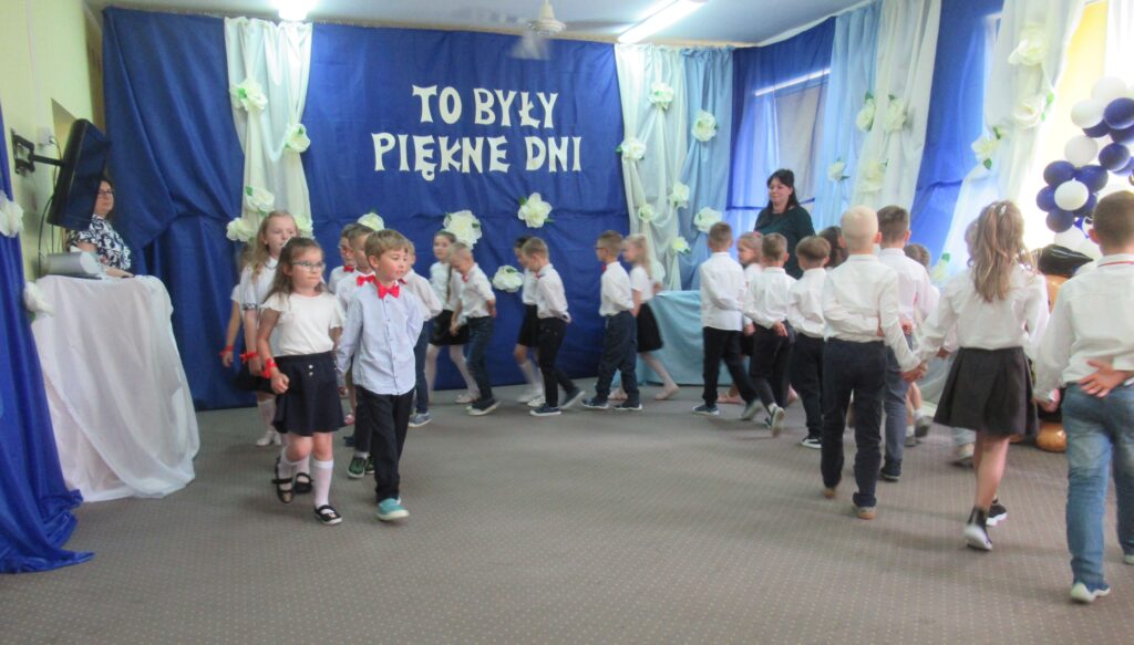 Zdjęcie przedstawia grupę ludzi w sali przedszkolnej.