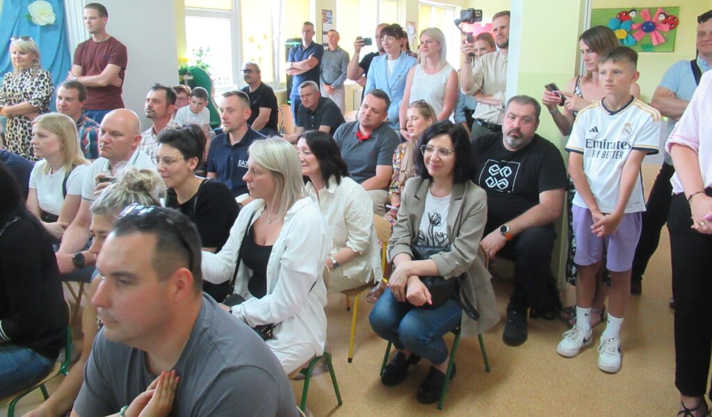 Zdjęcie przedstawia grupę ludzi w sali przedszkolnej.