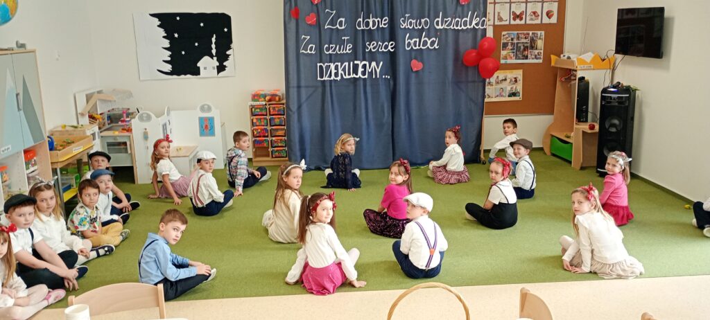 dzieci pozują do fotografii siedząc