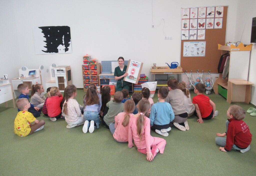 Zdjęcie przedstawia panią i dzieci w sali przedszkolnej.