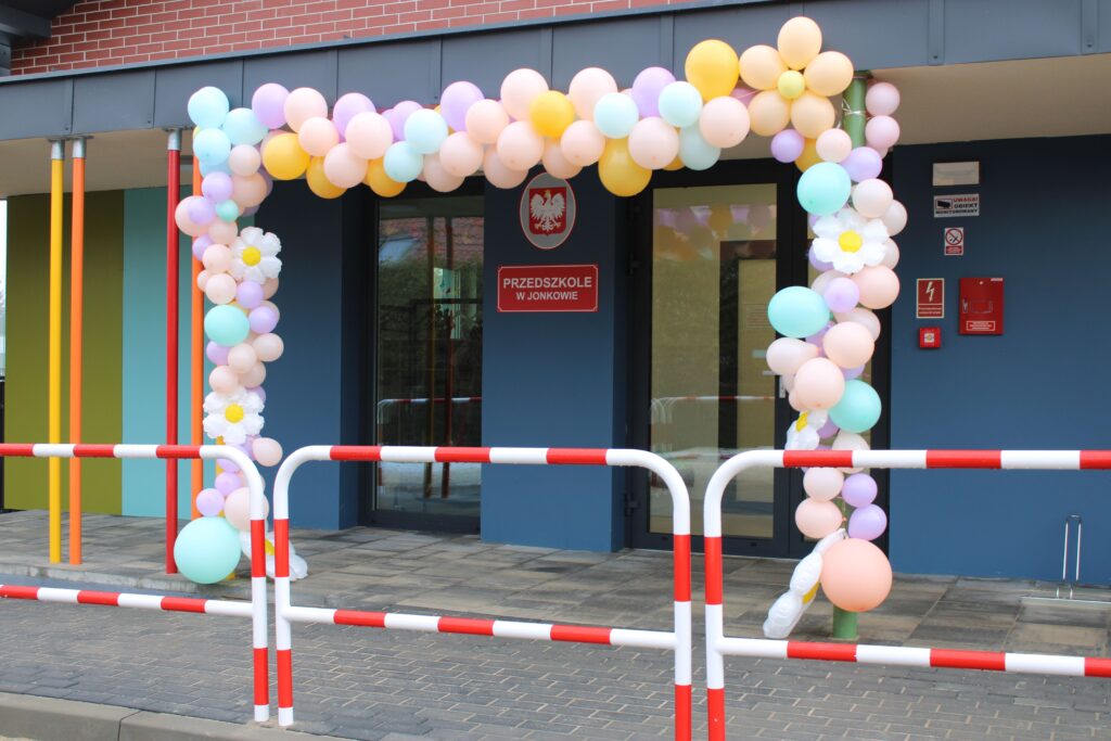 Zdjęcie przedstawia wejście do budynku przedszkola, wystrojone wokół balonami.