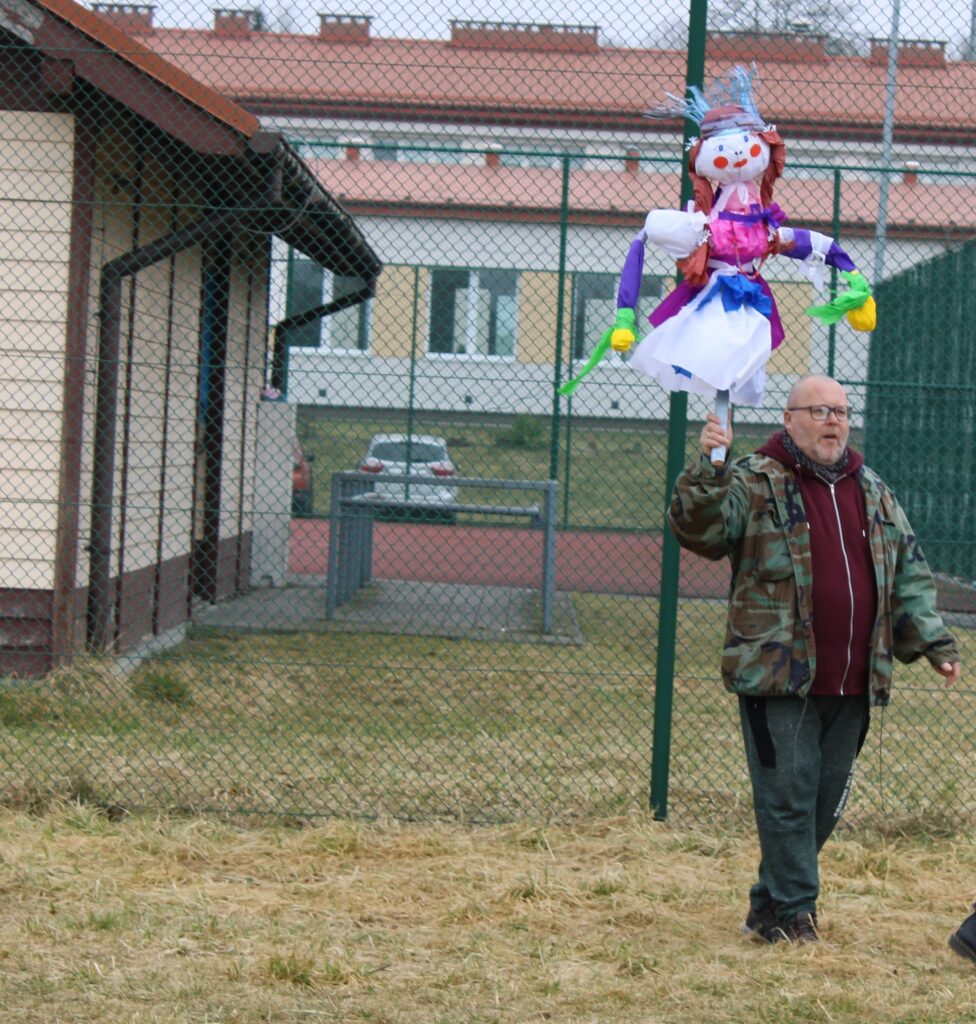 Zdjęcie przedstawia pana trzymającego w ręku kukłę - Marzannę.