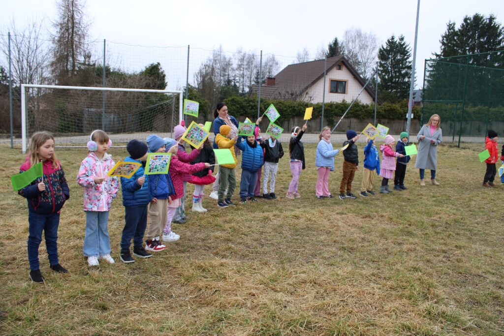 Zdjęcie przedstawia dzieci i panie na placu przedszkolnym.