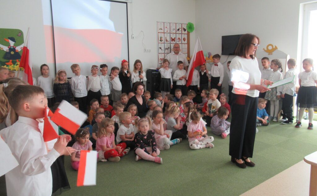 Zdjęcie przedstawia grupę ludzi w sali przedszkolnej.