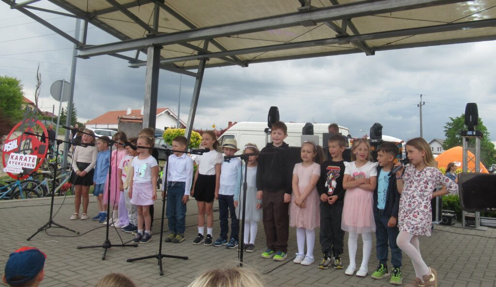 Zdjęcie przedstawia grupę dzieci na scenie.